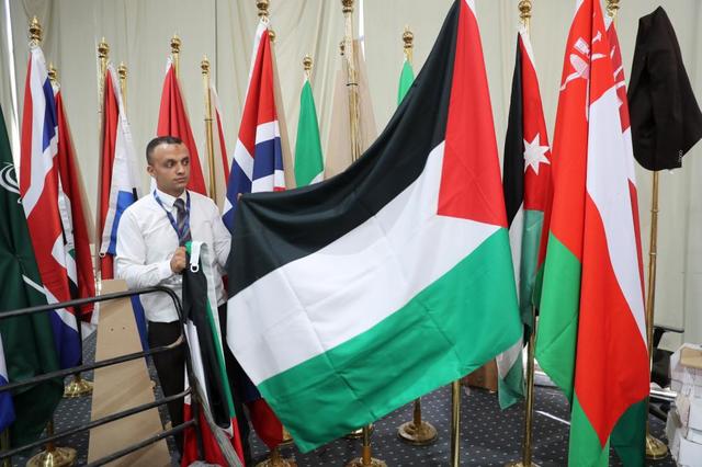 10月13日，在埃及沙姆沙伊赫，一名工作人員在沙姆沙伊赫峰會(huì)的媒體中心整理巴勒斯坦國(guó)旗。新華社記者 隋先凱 攝