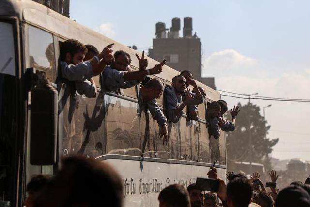 10月13日，巴勒斯坦獲釋人員乘坐大巴回到加沙地帶南部汗尤尼斯。新華社發(fā)（里澤克·阿卜杜勒賈瓦德 攝）