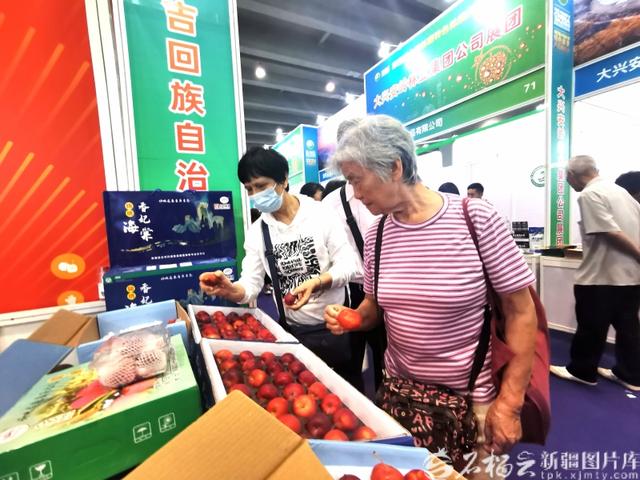 广州市民在第四届中国新疆特色林果产品博览会上了解香妃海棠果（资料图）。石榴云/新疆日报记者 曹华摄