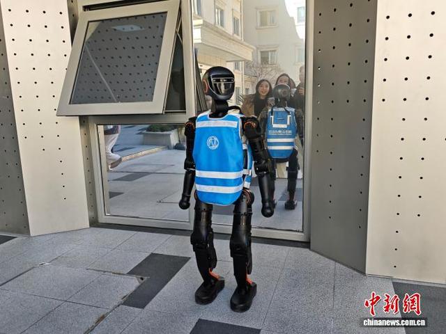 北京中关村AI原点社区内，采访调研团记者正与机器人互动。中新闻记者 刘越 摄