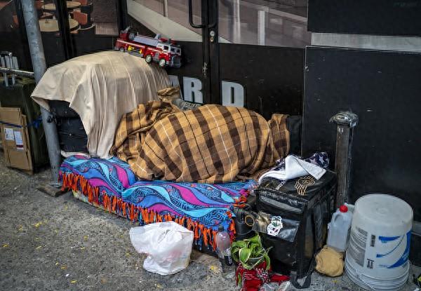 11月11日，美国纽约，一名无家可归者带着自己的物品在人行道上睡觉。 视觉中国