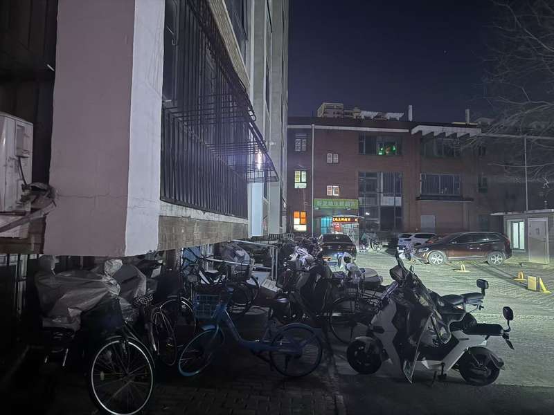 12月7日晚，天通中苑小区，紧贴着居民楼停放的电动车。新京报记者 曹晶瑞 摄