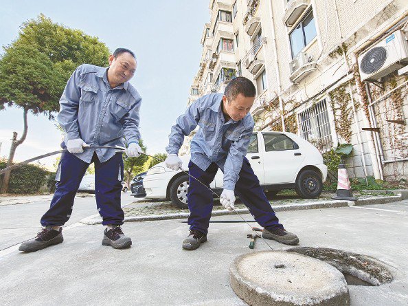 物业工作人员在疏通小区污水管道