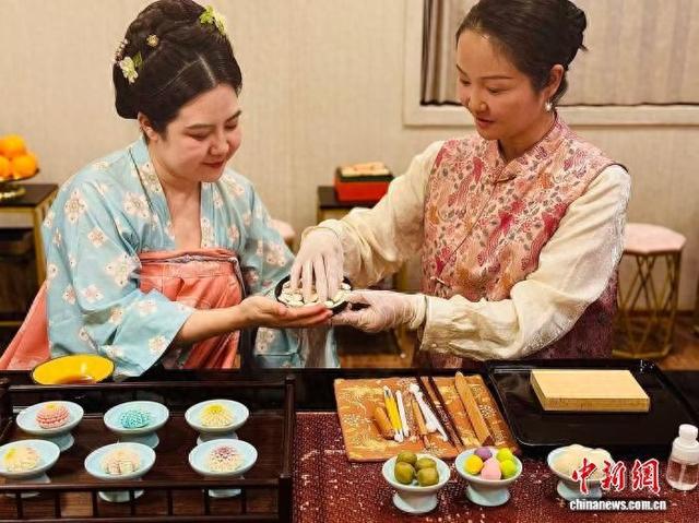 12月8日，陕西西安，李欢(左)与卓美艳展示唐果子制作过程。 杨英琦 摄