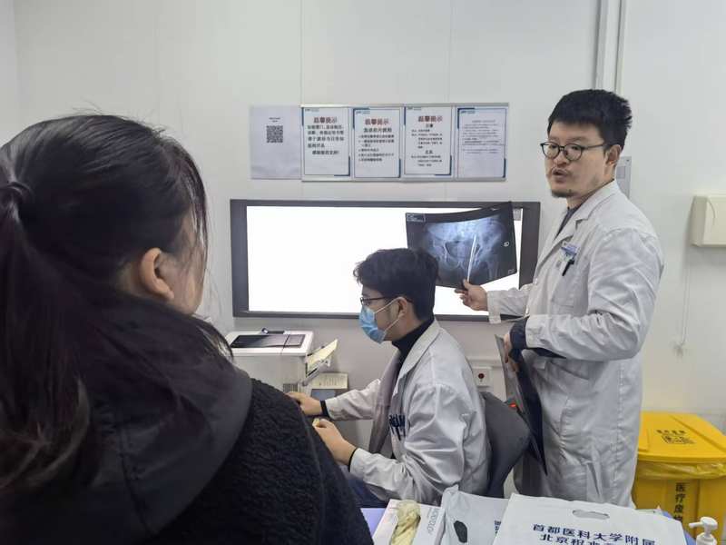 姚东晨（右一）正在接诊。北京积水潭医院