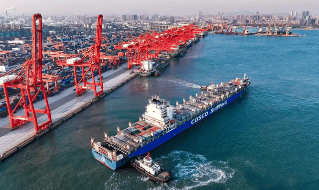 在山东港口日照港集装箱码头，满载集装箱的船舶驶离港口（无人机照片）。 新华社发（李大伟摄）