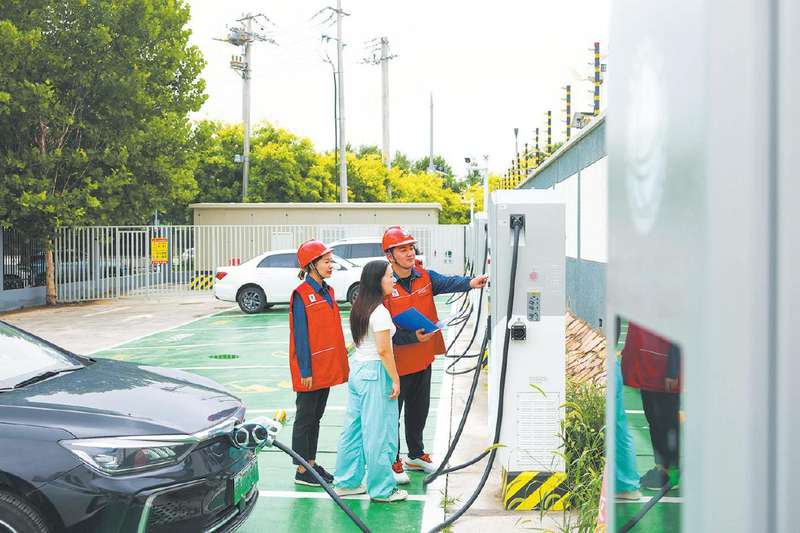 2025年7月3日，国家电网首都电力（亦庄）共产党员服务队队员在同宁超充站为客户提供新能源汽车充电服务。 张庆玉 摄