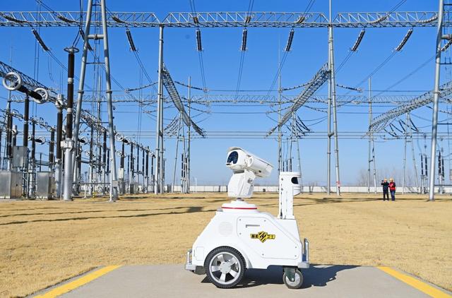 2025年2月10日，安徽滁州，在南谯区500千伏变电站，运维人员和一台5G智能机器人正在对变电站主要设备进行智能特巡。视觉中国 图