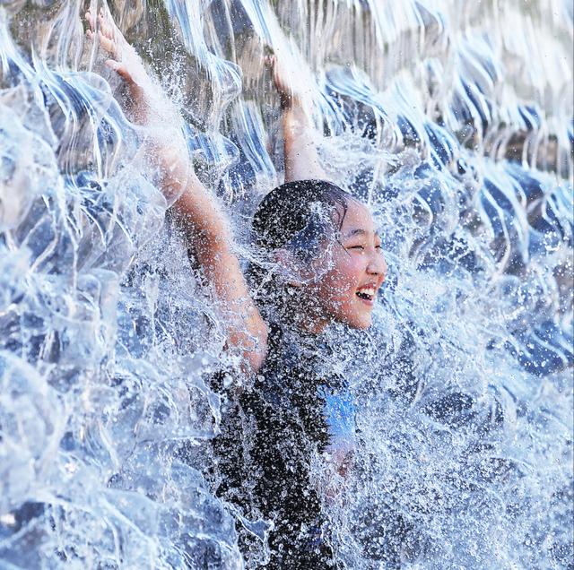 2025年7月27日，韩国京畿道，儿童在光教湖水公园玩水消暑。视觉中国 图