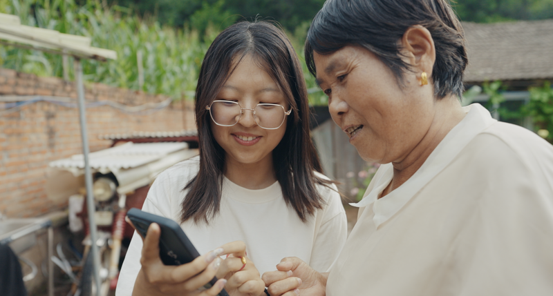 于琳娜向村民奶奶演示如何使用多多买菜。金家伟摄