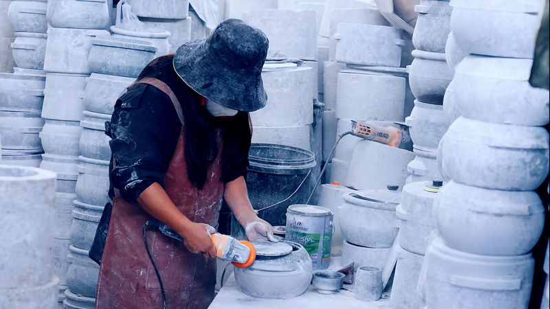 墨脱创业者旺姆用网购的工具打磨石锅。张淼摄