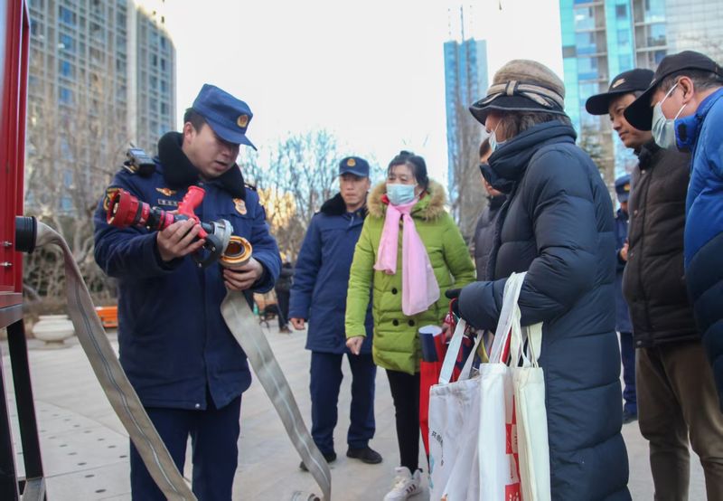 消防人员在给居民介绍消防水带的结构。通州消防供图