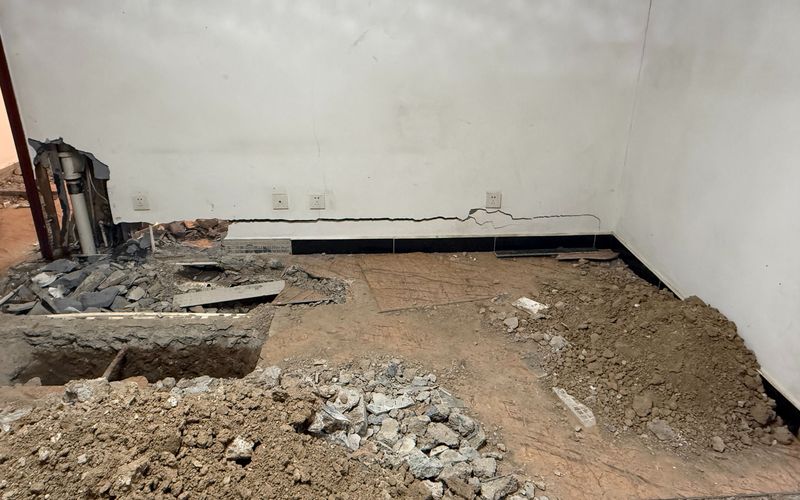 冯女士家客厅地面出现下沉，检测人员开挖地面探查原因。新京报记者 张建林 摄