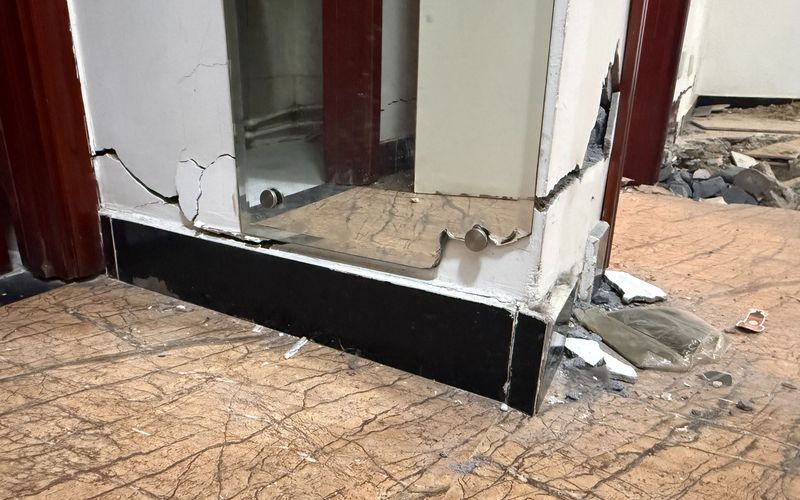 因墙体开裂，冯女士家卫生间外的仪容镜一角已被挤碎。新京报记者 张建林 摄