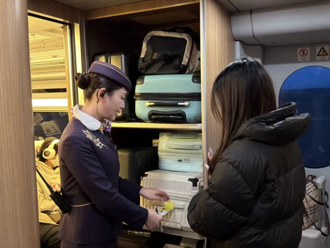 上海客运段列车员为旅客贴上行李防错拿贴