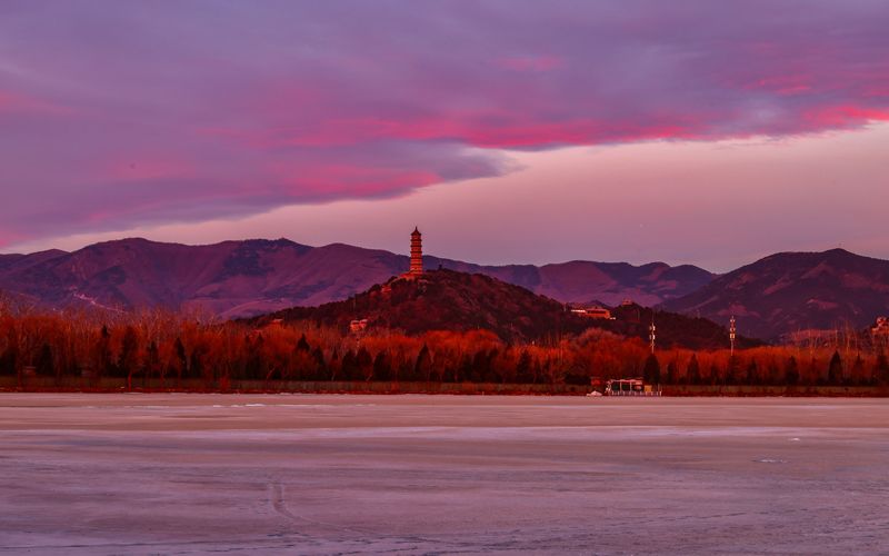 在朝霞的映衬下，远处的西山景色更显壮丽。颐和园供图