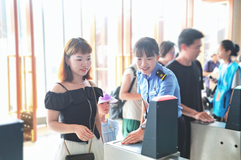 杜京林（左二）帮助旅客检票。首都文明办供图