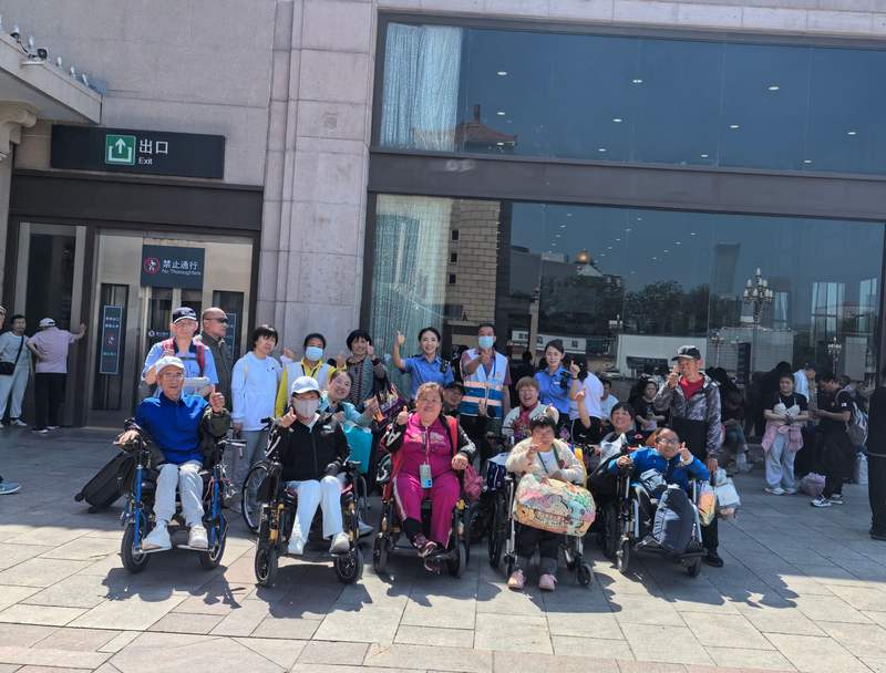 杜京林（三排中）护送特殊旅客群体。首都文明办供图