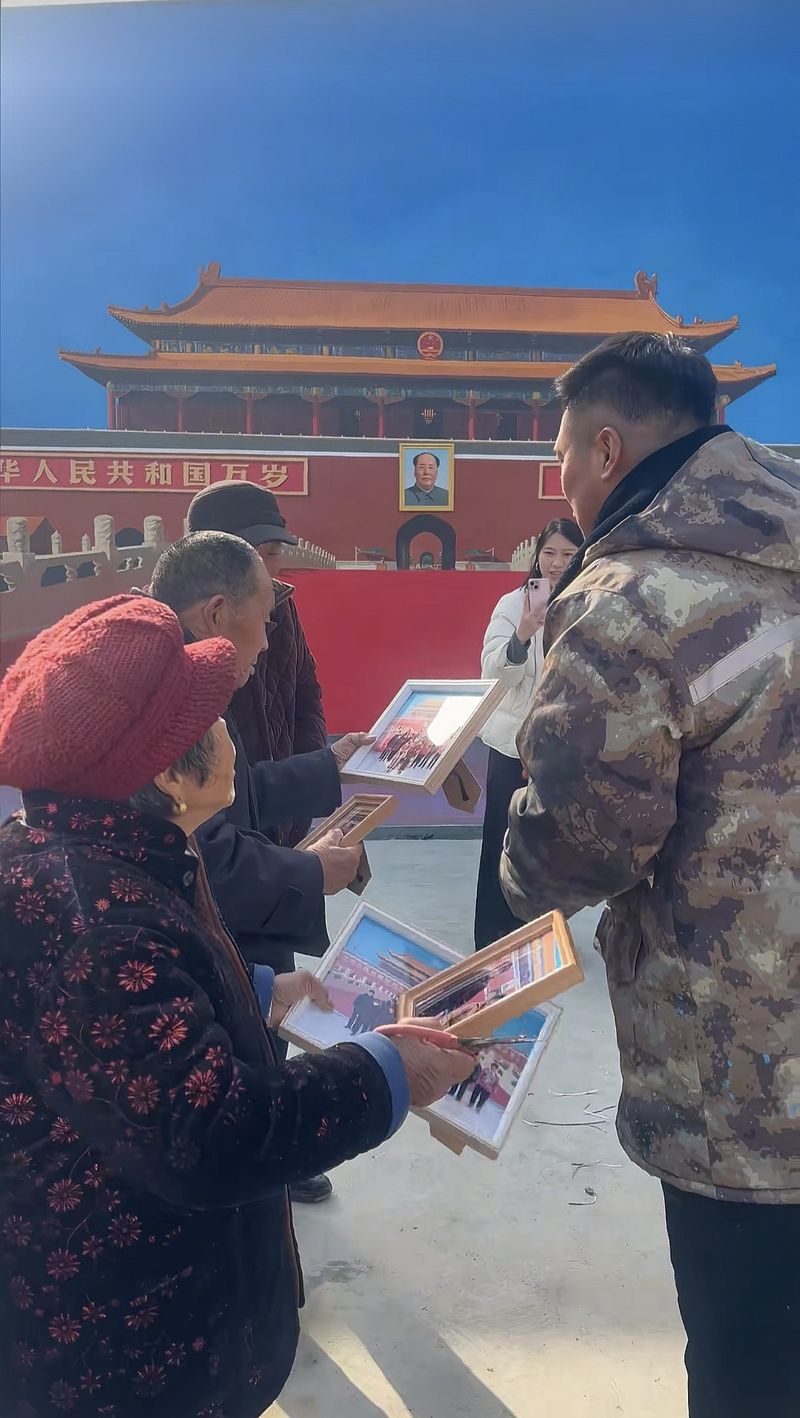 2025年12月25日，吴承言把天安门墙画前的合照发给村里的老人们。受访者供图