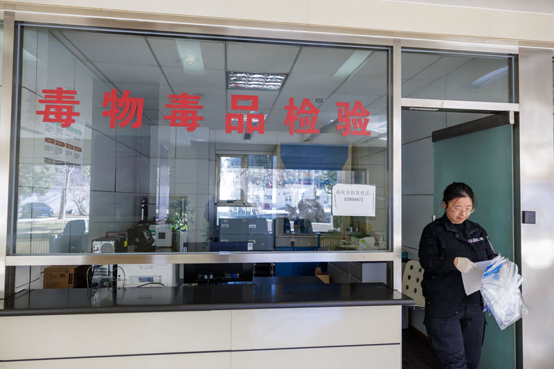 2025年12月30日上午，孙婧拿着一线办案民警刚刚送来的证物袋，里面有需要检验的血液样本。新京报记者 王子诚 摄