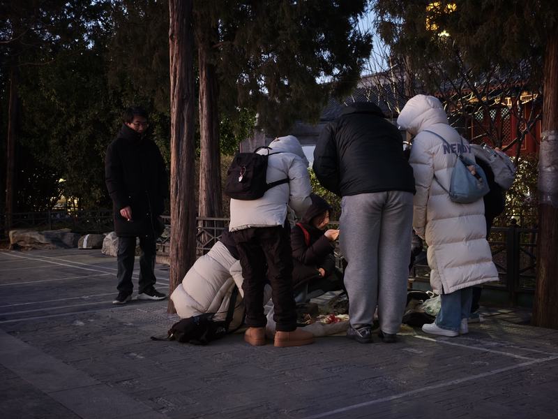 天色渐暗，围着“木雕大爷”的人群渐渐少了。新京报记者 王巍 摄