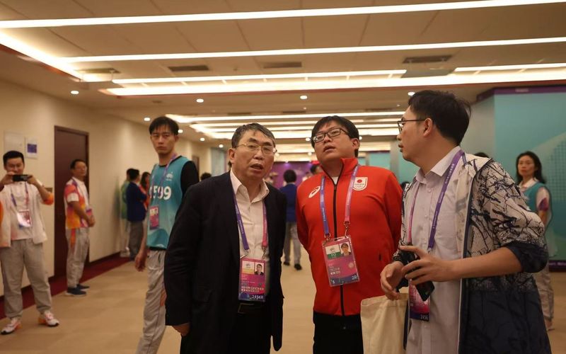 2023年杭州亚运会期间，聂卫平（左一）和儿子、日本围棋代表团团长孔令文（中）在一起。新京报记者 王飞 摄