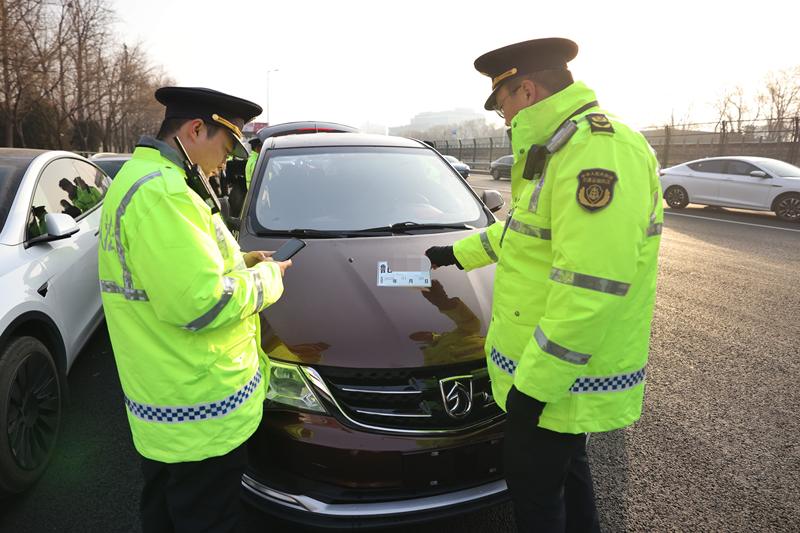 交通执法人员对一辆悬挂山东临牌的合执违法营运车辆开展检查。新京报记者 王贵彬 摄