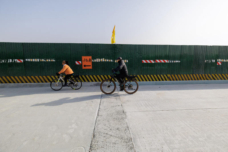 村民骑行在新桥与旧桥连接处。新京报记者 王子诚 摄