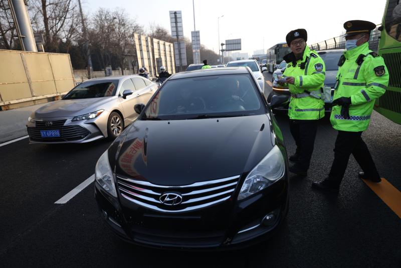 一辆悬挂临牌的“黑车”被交警和交通执法人员拦停，接受联合执法调查。新京报记者 王贵彬 摄