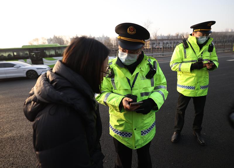 交通执法人员向乘客询问情况。新京报记者 王贵彬 摄