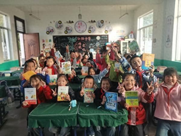 泾川县党原镇中心小学三年级同学和他们“吃过”的书合影。受访者供图
