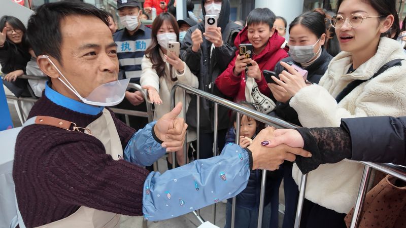 “鸡排哥”李俊永在慈溪“巡炸”现场与消费者互动。新京报贝壳财经记者俞金旻 摄