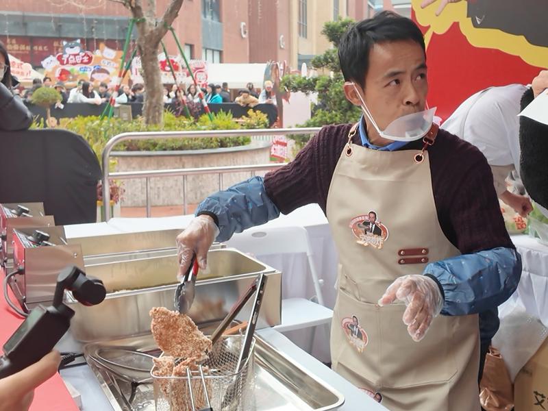 “鸡排哥”李俊永在慈溪“巡炸”现场炸鸡排时与消费者互动。新京报贝壳财经记者俞金旻 摄