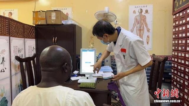 图为医务人员借助“AI中医体质辨识机”为外国友人进行体质辨识。广西医科大学第一附属医院 供图