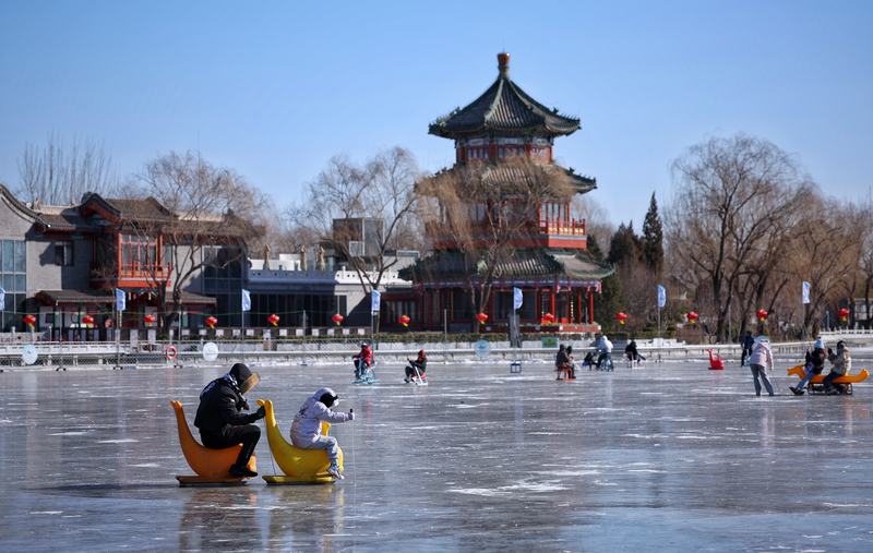 1月20日，什刹海后海冰场，游客们在滑冰车。新京报记者 薛珺 摄