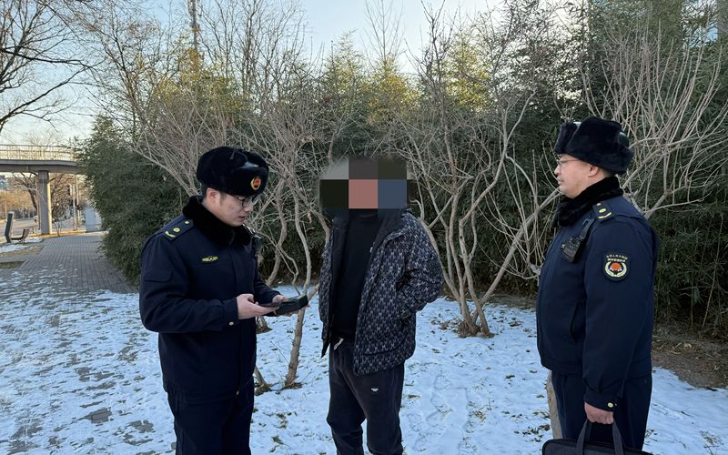 执法队员对随地便溺的男子进行处罚及引导。海淀区城管执法局供图