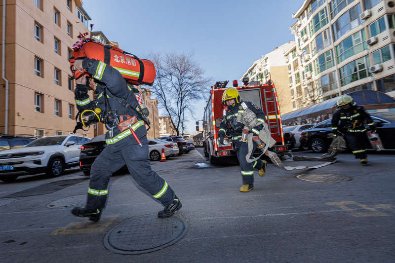 消防员携带装备向高层建筑10层“起火点”发起冲刺。新京报记者 王子诚 摄