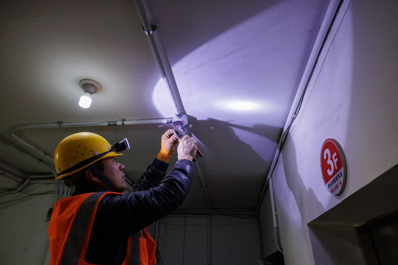 兴华园小区工人正在安装烟感报警器。新京报记者 王子诚 摄