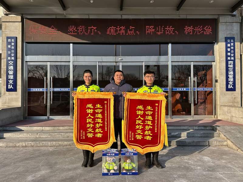 市民李先生向两位铁骑交警赠送锦旗，表达感谢。新京报记者 裴剑飞 摄