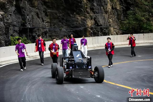 清华大学极限竞速战队队员在天门山赛道追随AI赛车上山。（清华大学车辆与运载学院供图）