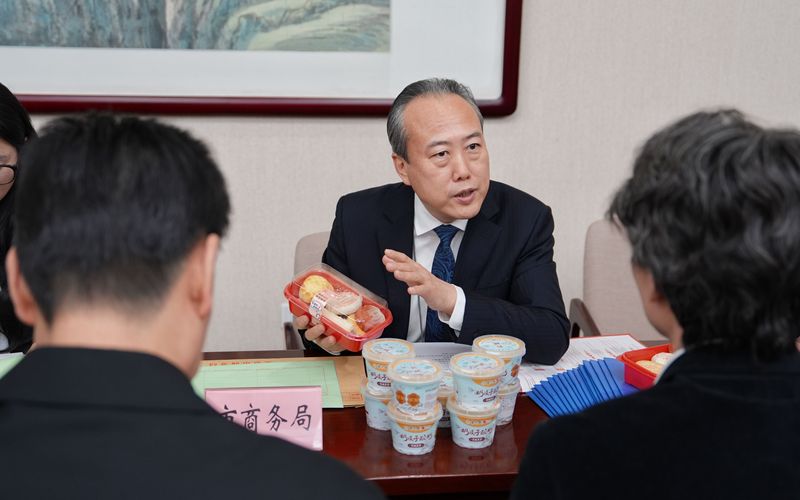 北京市商务局局长朴学东向代表、委员推荐北京稻香村的特色点心。新京报记者 陶冉 摄