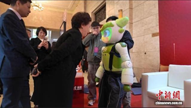 1月28日，代表委员在成都市两会会场与情感交互人形机器人“爱湫”对话。 何美锟 摄