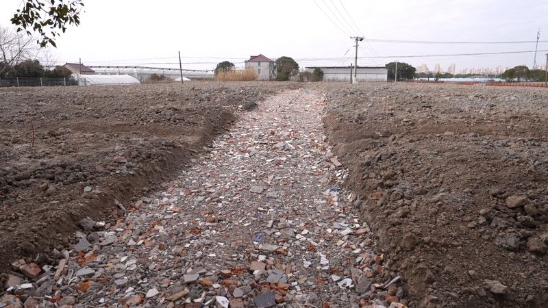 被倾倒渣土损坏的农用地。上海浦东警方供图