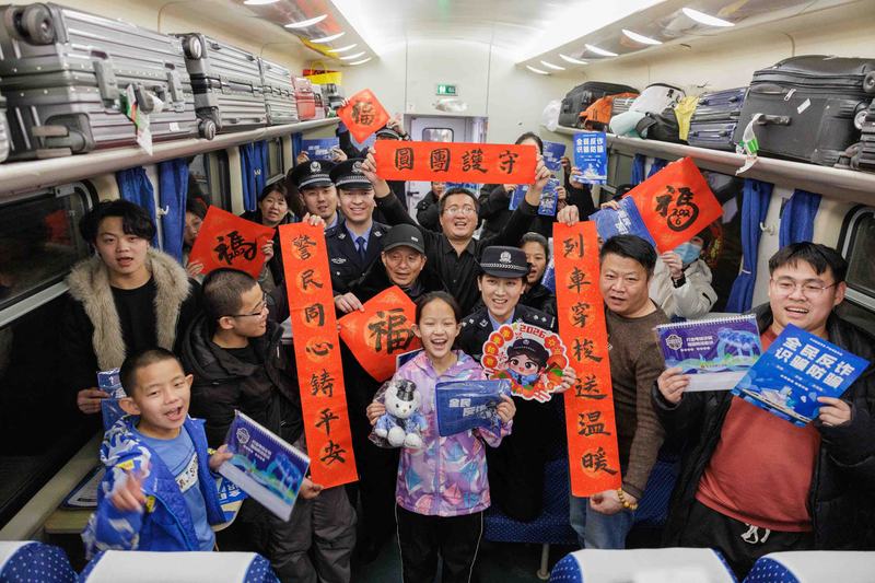 2月2日凌晨，K4069次列车，乘警与旅客合影。新京报记者 王子诚 摄