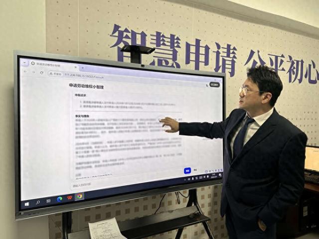 南宁市劳动人事争议仲裁院调解庭副庭长黄鑫向媒体演示平台如何运行。吴文旭/摄