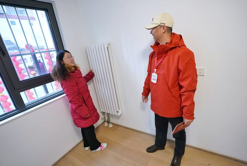 居民体验暖气片温度。新京报记者 薛珺 摄