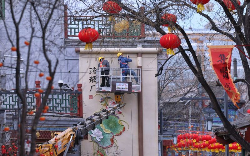 2月5日，琉璃厂文化街，工作人员正在布置新年装饰。新京报记者 薛珺 摄