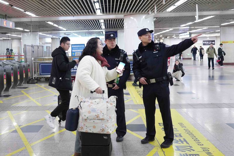 2月4日上午，北京西站地铁站内，执勤民警在给游客指路。北京公安供图