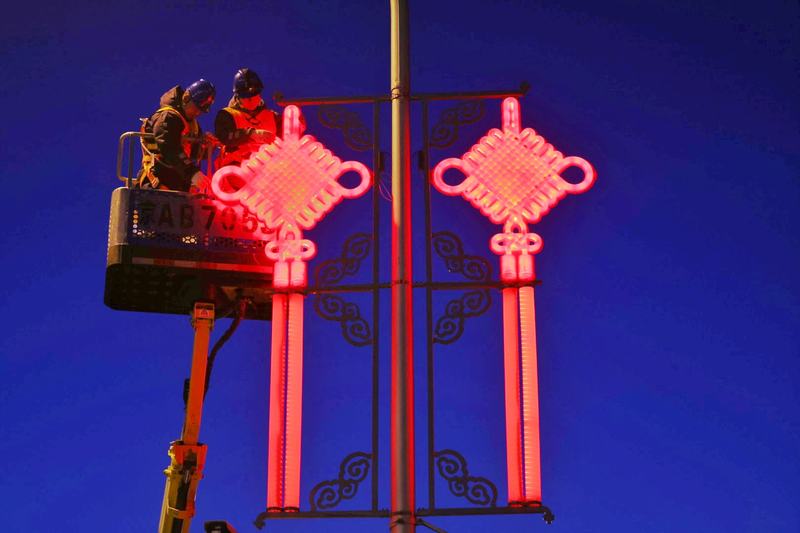 国网北京电力城市照明管理中心工作人员站在升降台上维护灯饰。新京报记者 李木易 摄