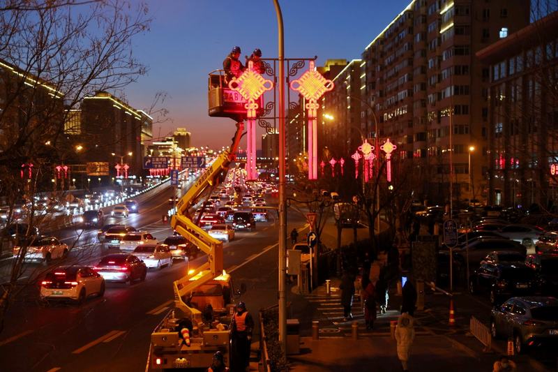 长安街木樨地桥附近，国网北京电力城市照明管理中心工作人员调试中国结灯饰。新京报记者 李木易 摄